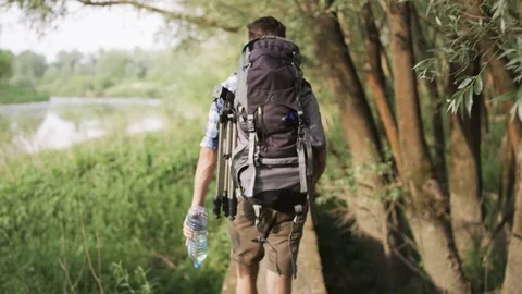 Young Man Walking Along the River. The Sun is Shining Stock Footage 77676343