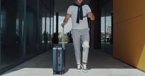 A young man walking and putting his sunglasses on while walks Stock Footage 142287227