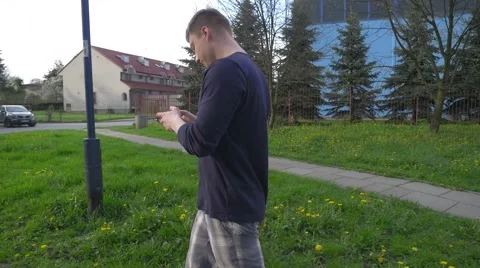 Young man walking and using mobile phone. Video stock 62519114