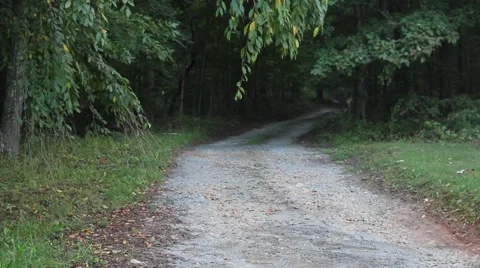 Young man walking barefoot down a dirt road Stock Footage 44445247