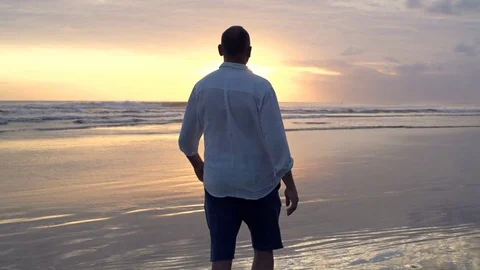 Young man walking on beach during sunset, super slow motion 120fps Stock Footage 81171960