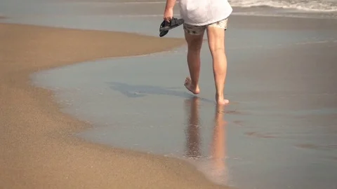 Young man walking on the beach, focus on legs, super slow motion Stock Footage 70471009