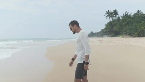 Young man walking at beach Stock Footage 109421984