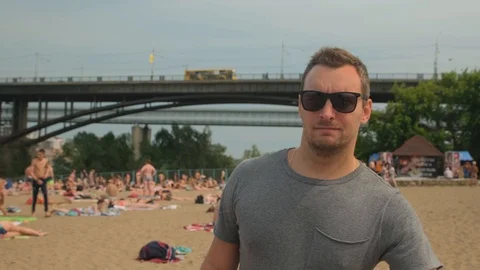 A young man walking on the beach.The man on the beach.A man in sunglasses 動画素材 112350328
