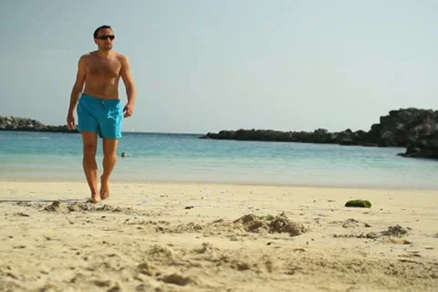 Young man walking on the beach NTSC Stock Footage 10894435