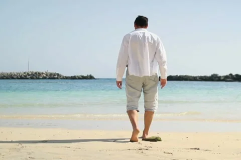 Young man walking on the beach NTSC Stock Footage 10901871