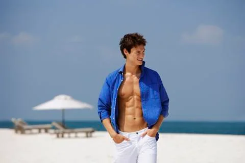 Young man walking on beach Stock Photos