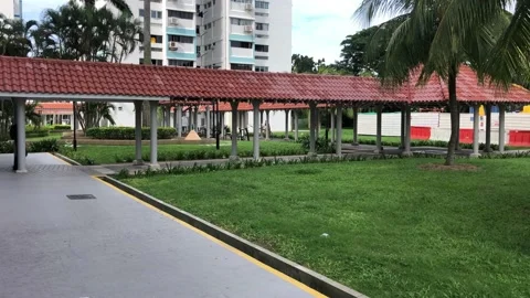 Young man walking a covered walkway on HDB estate. Stock Footage 138342292