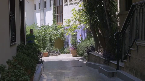 Young man walking down old city street Stock Footage 106396816