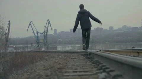 Young Man Walking Down Rail Road Tracks Stock Footage