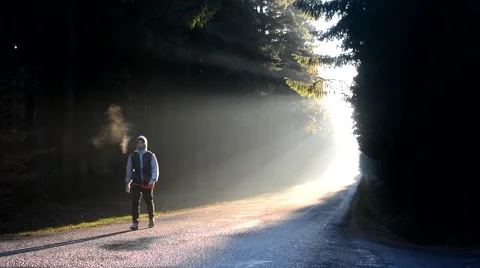 A young man walking down the road in morning sunrise Video stock 57913801