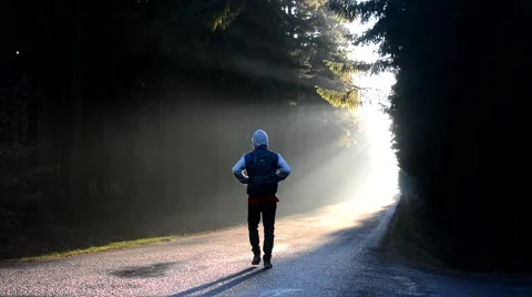 A young man walking down the road in morning sunrise Video stock 57913868