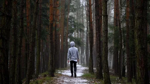 A young man walking down the road in the spring forest. 스톡 동영상 86895716