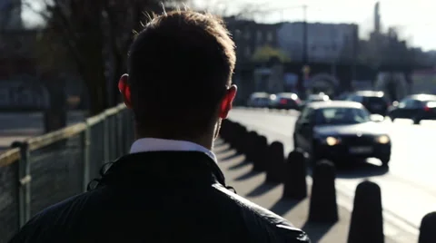 Young man walking down a sidewalk, slow motion. Видео 48362781