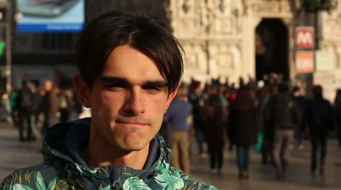 A young man walking down the street on a sunny day. Milan, Italy. Steadicam shot Stock Footage 60240164
