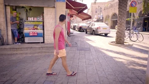 Young man walking down street Stock Footage 81207865