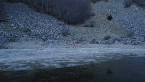 Young man walking in the forest. Top view of  frozen Lake Stock Footage 101012661