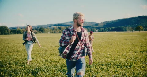 Young Man Walking On Grass With Friends Stock Footage 252018342
