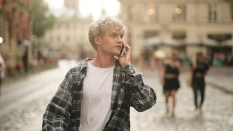 Young man walking with mobile phone at street. Smiling guy call phone outdoors Stock Footage 158846297