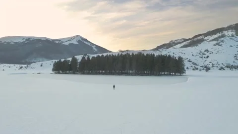 Young man walking on mountain at sunset, drone shot winter Stock Footage 155336976