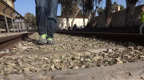 Young man walking on old rail road 스톡 동영상 20523766