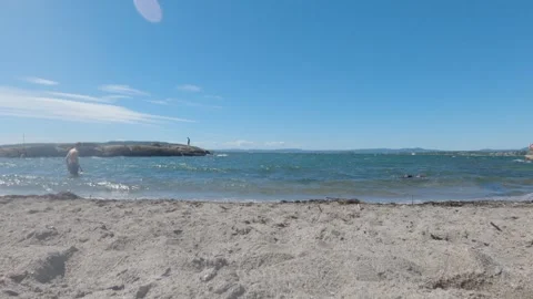 Young Man Walking Out of Ocean onto Sandy Beach at Bygdoy Oslo Norway Stock Footage 342208158