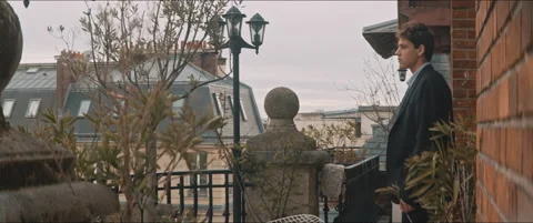 Young man walking out a rooftop balcony Stock Footage 203586590