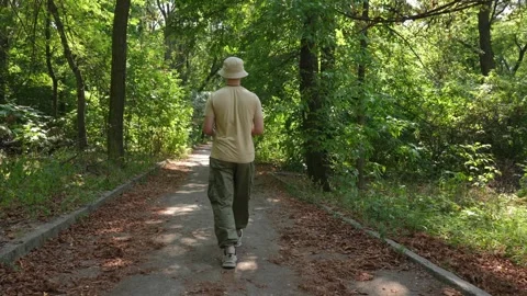 A young man is walking in the park. Vídeo Stock 285221428