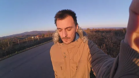 Young man walking on road filming himself Stock Footage 148568787