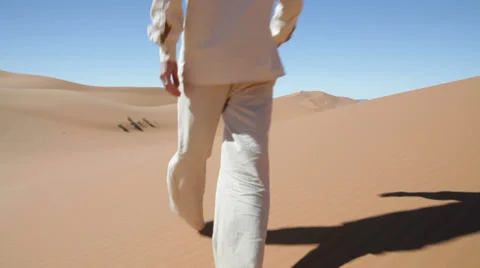 Young man walking up sand dunes during a sunny day; Erg Chebbi, Maroc - HD1080p Stock Footage 34446813