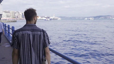 Young man walking by the sea. Stock-Footage 212689296