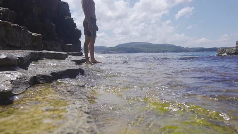 Young man walking on the seashore. Vídeo Stock 212499875