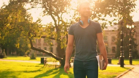 Young man walking talking by mobile outdoors slow motion Stock Footage 101485104