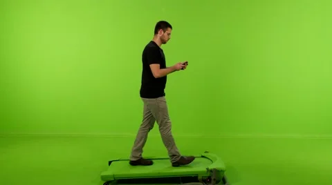 Young man walking texting greenscreen 4K Stock Footage 63113674
