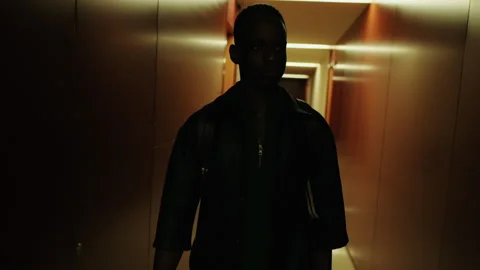 Young Man Walking Thoughtfully Down Hotel Hallway Stock Footage 303778092