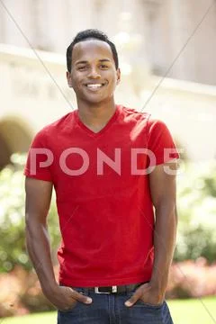 Young man walking through city street Stock Photos
