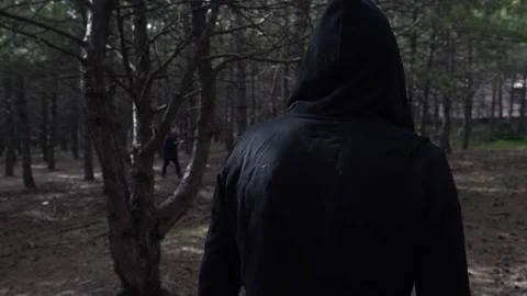 Young Man Walking Through The Forest In A Black Hoodie. Cinematic 4K Stock Footage 180399141