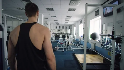 Young man walking through a gym shot from the back Stock Footage 105895649