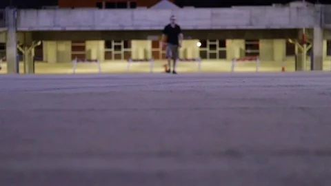 Young Man Walking Through Parking Garage At Night Video stock 99925669