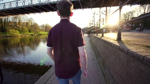 Young man walking tracking outdoors bridge evening Spring Summer beautiful river Stock Footage 74751858