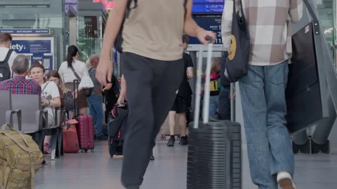Young Man Walking in Train Station Pulling Rolling Suitcase Stock Footage 337725772