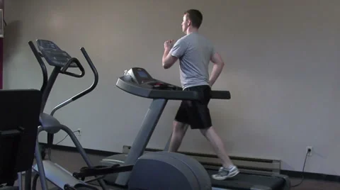 Young man walking on a treadmill. medium shot. Stock Footage 49862959
