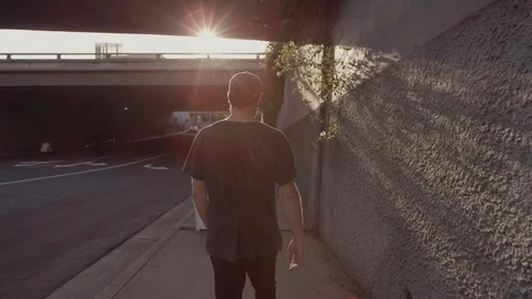 Young man walking under highway Vídeo Stock 89976614