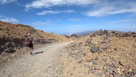 Young man walking volcano path Martian landscape Stock Footage 116015595