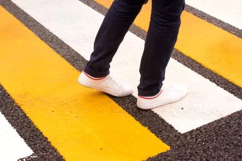 Young man walking zebra crossing Stock Photos