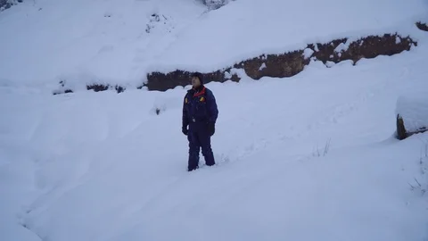 A young man walks alone through a snowy forest. Young pretty tourist sneaks Stock Footage 99969176
