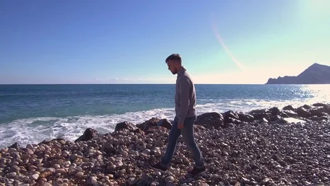 A young man walks on the beach. Stock Footage 83232700