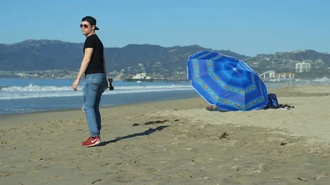 Young man walks on beach Stock Footage 86535633