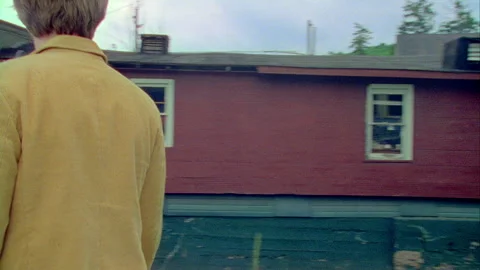 A young man walks by a building in on old town, Monticello, NY 1989. Stock Footage 272250544