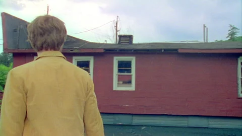 A young man walks by a building in on old town, Monticello, NY 1989. Stock Footage 272250570